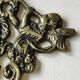 Decorative coat hook with cherubs/putti in aged brass.