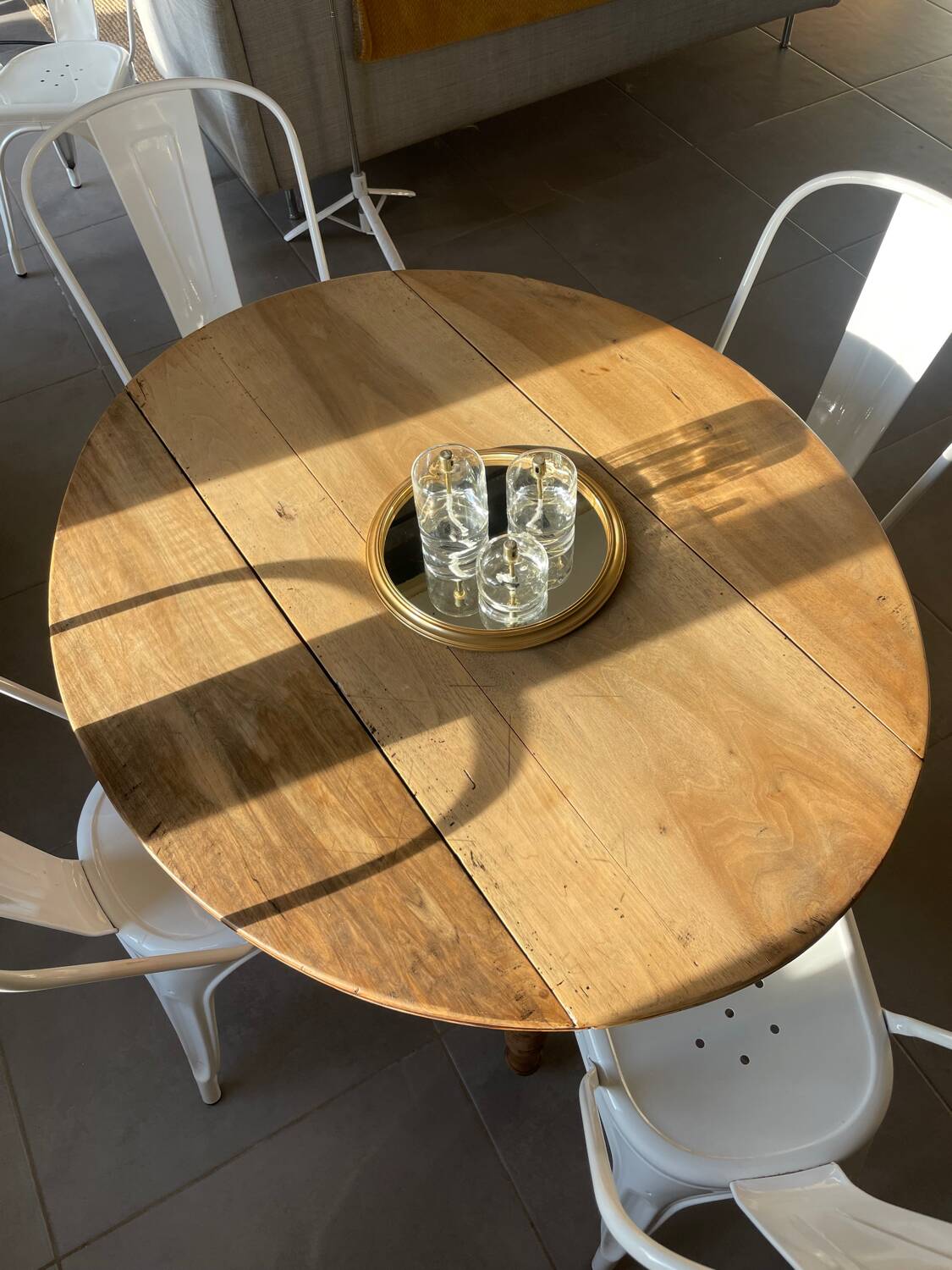 Oval wooden table with drop-leaf edges.