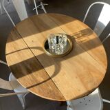 Oval wooden table with drop-leaf edges.