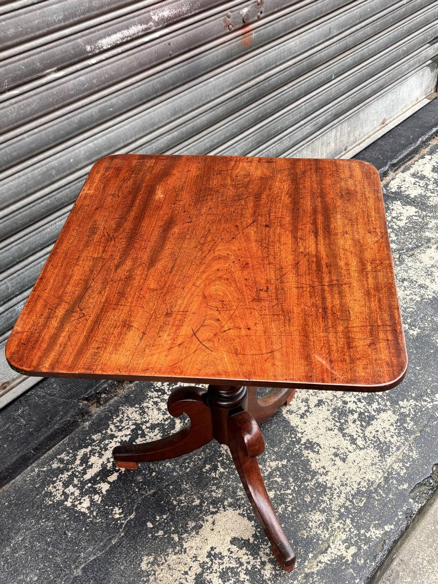 19th-century solid mahogany table with a tilting top and brass mechanism.