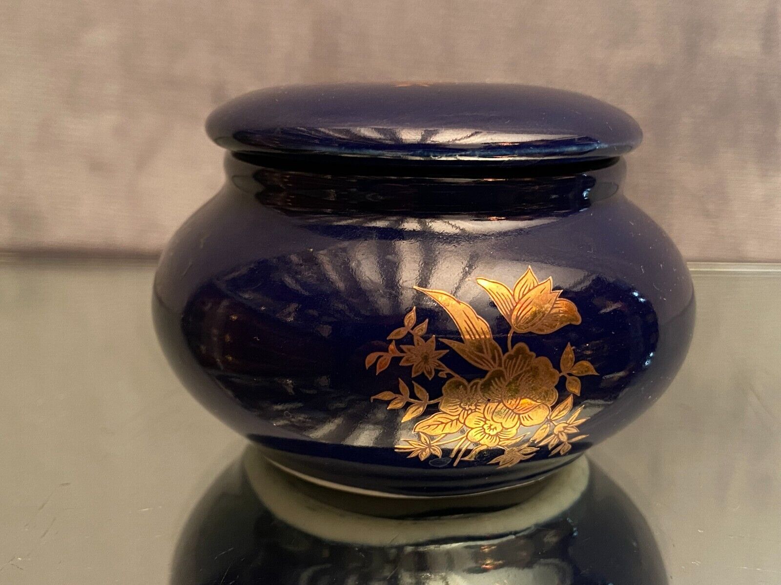 Porcelain candy box with golden floral decoration on a midnight blue background