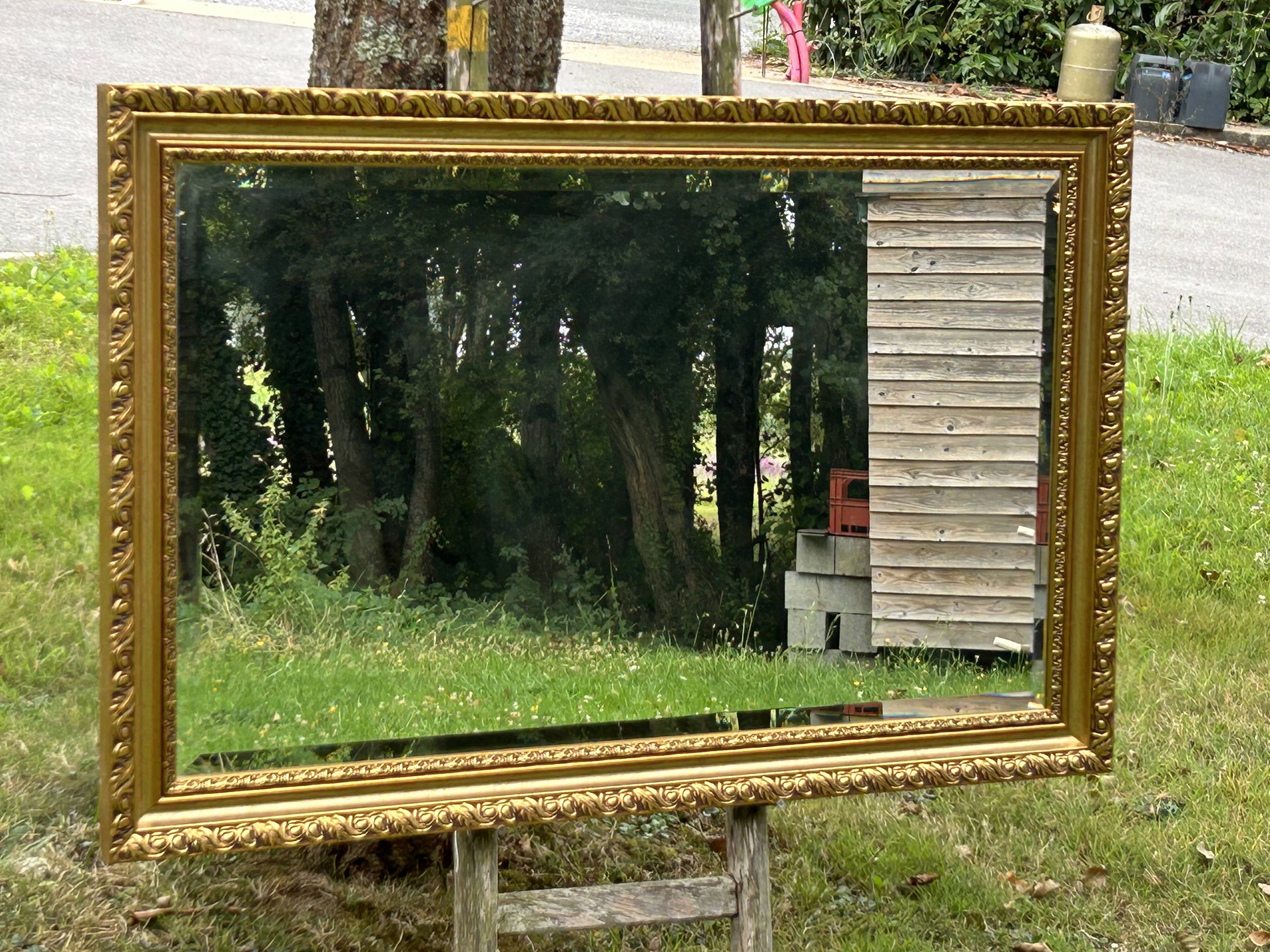 Large beveled mirror in wood and gilded stucco
