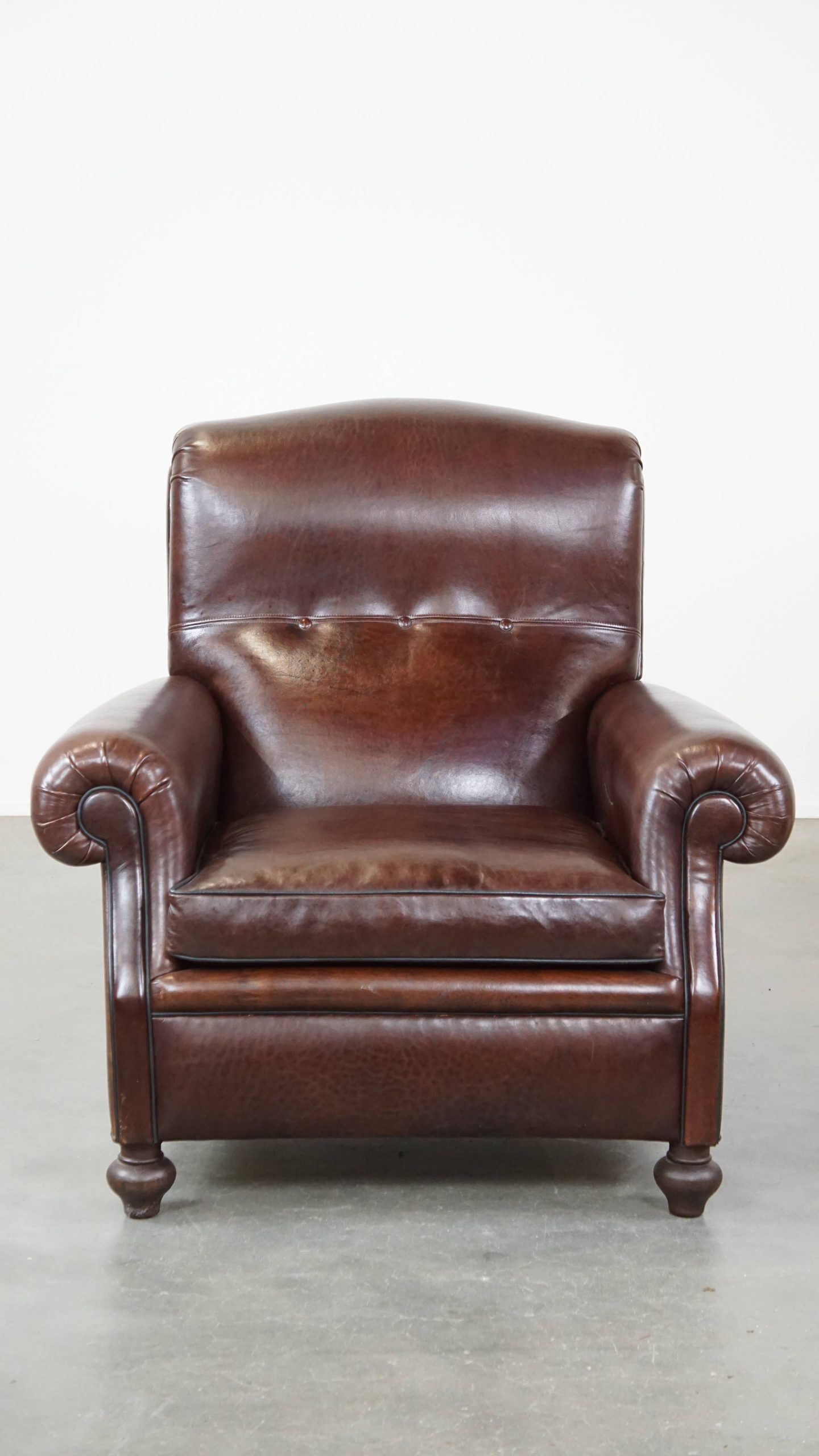 Comfortable and correct dark antique sheepskin English armchair in very good condition