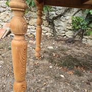 Folding drop-leaf table made of raw solid wood.