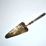 Antique silver-plated pie server with a brass blade decorated with roses.