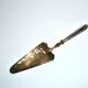 Antique silver-plated pie server with a brass blade decorated with roses.