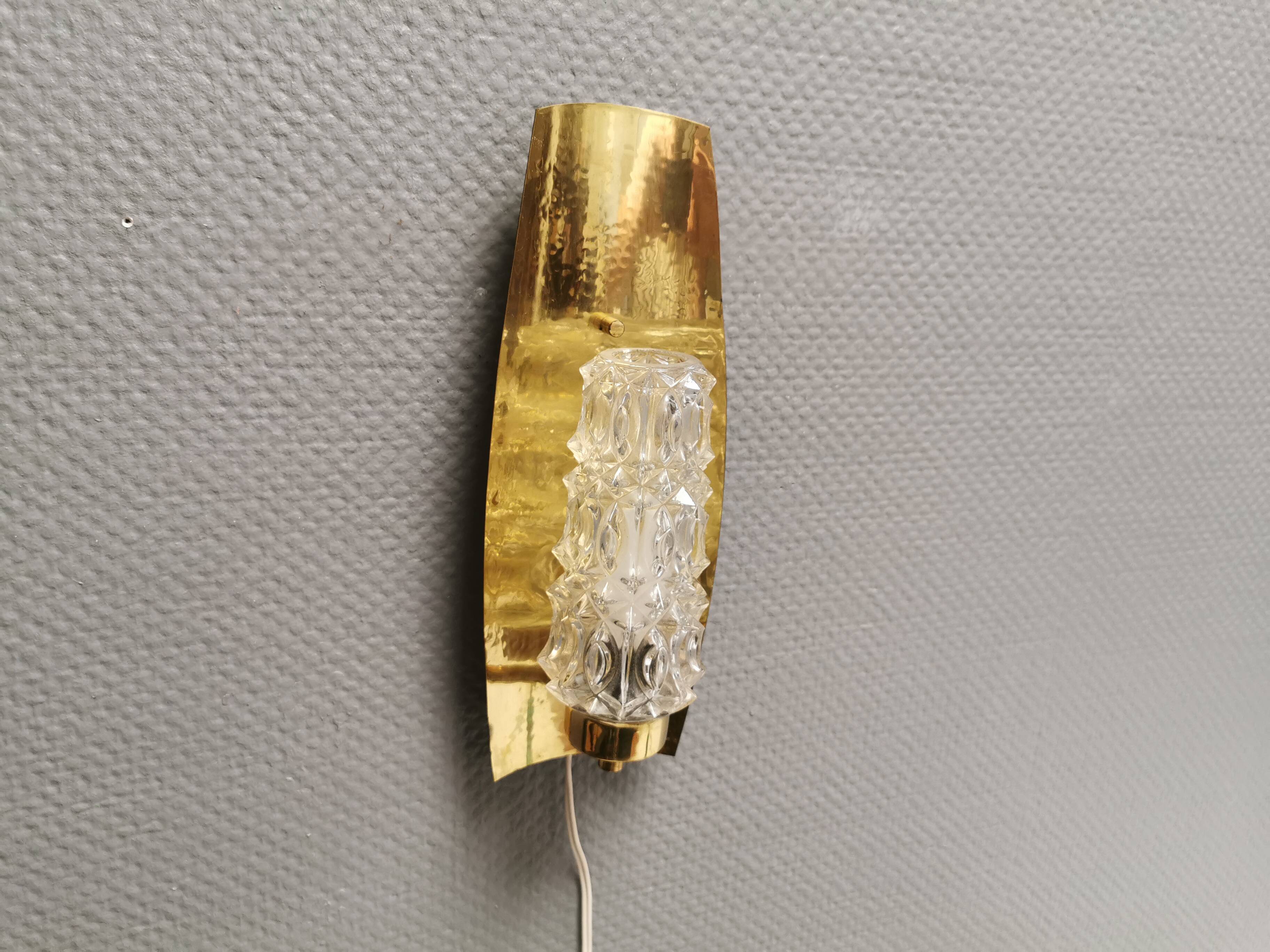 Older wall lamp in brass with hard pressed glass shade.