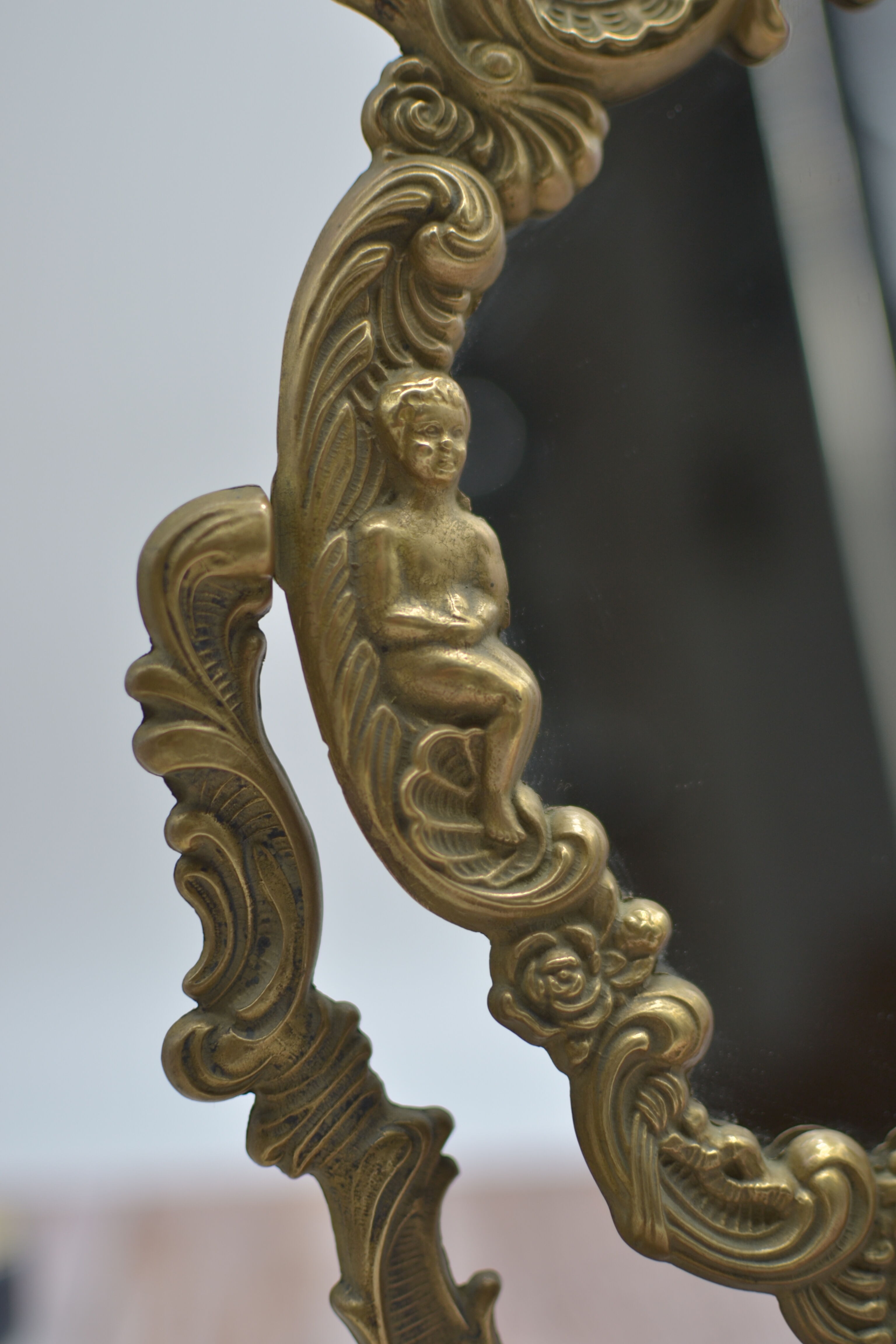 Adjustable psyche mirror of 33 centimeters in gilded bronze with angel ornament