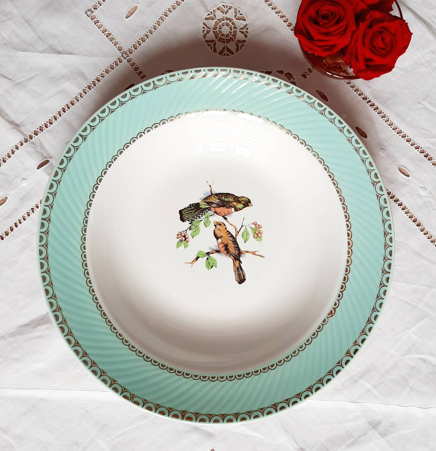 Old mismatched earthenware dinner plates accompanied by a deep dish