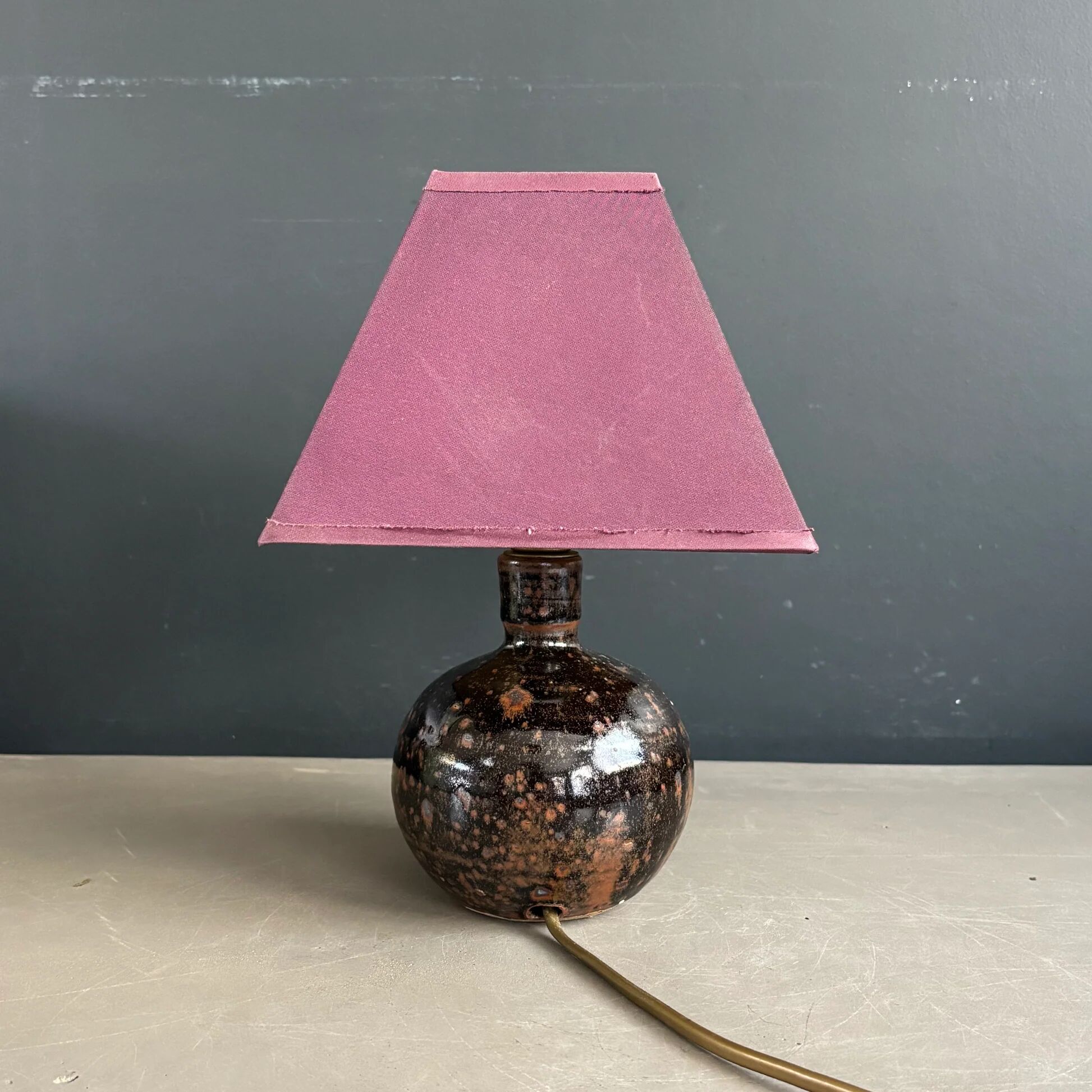 Ceramic floor lamp with a pyramidal shade and square base.