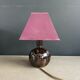 Ceramic floor lamp with a pyramidal shade and square base.