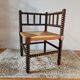 Old wooden turned spindle fireside chair with a straw seat.