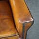 Art deco armchair in sheepskin with black piping and decorative nails