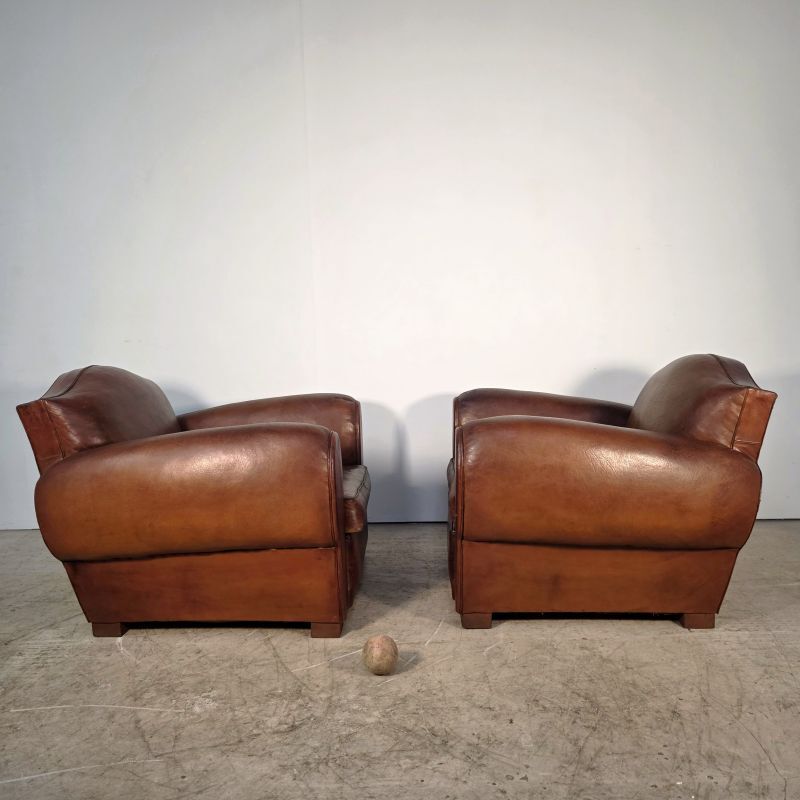 Important pair of Havana leather club armchairs, moustache models, mid-20th century.
