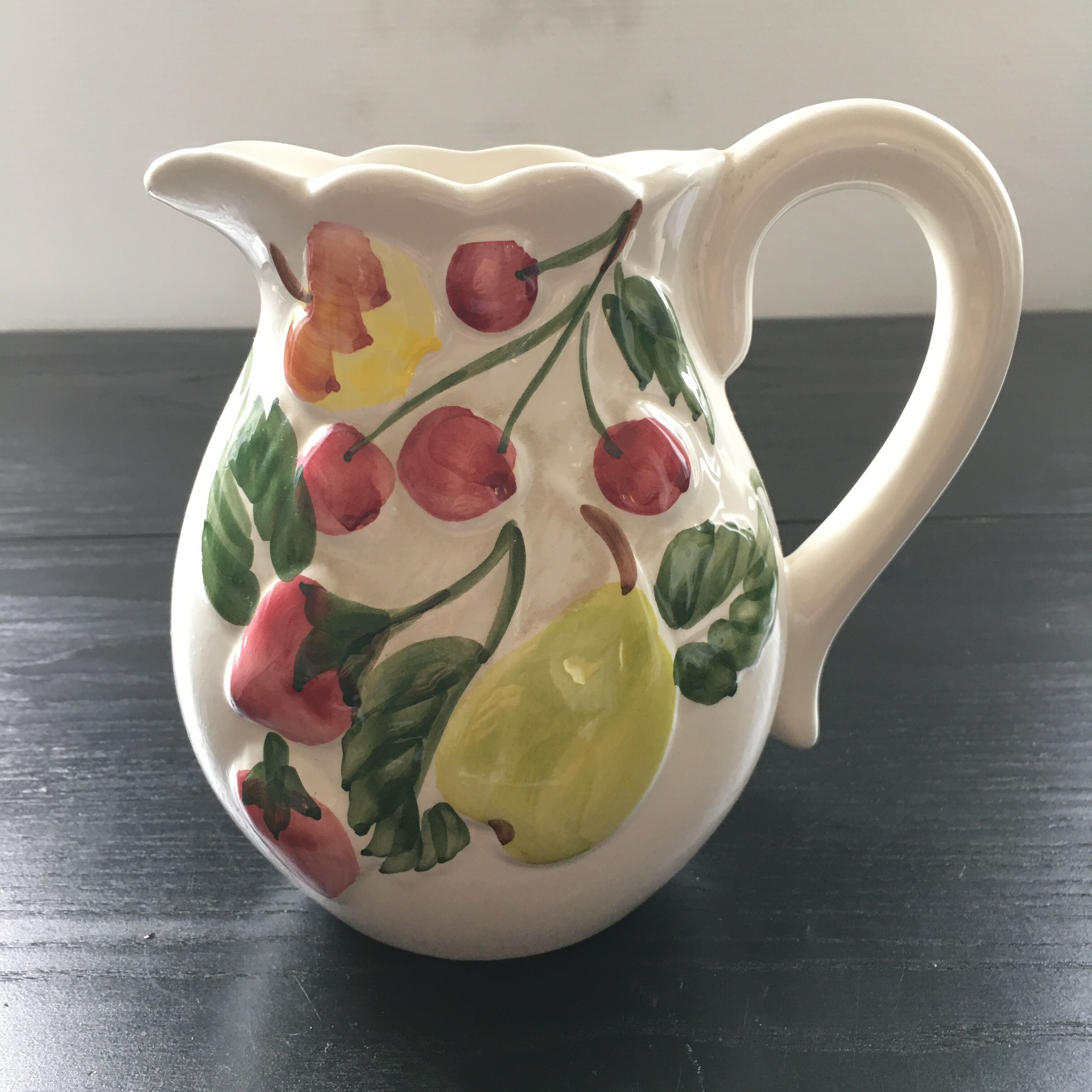 Fruit-decorated pitcher in slipware