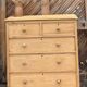 Large antique English chest of drawers in raw solid wood.