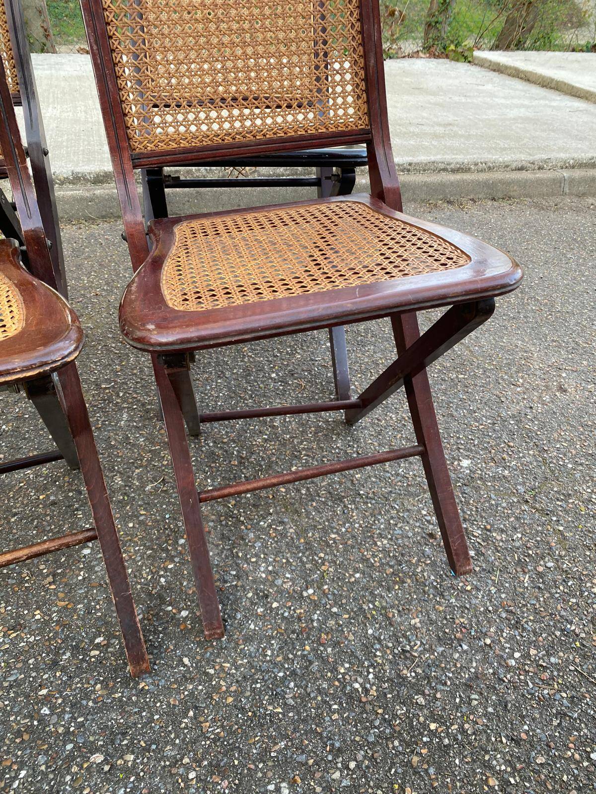 4 cane-seated solid wood folding chairs to be repaired.