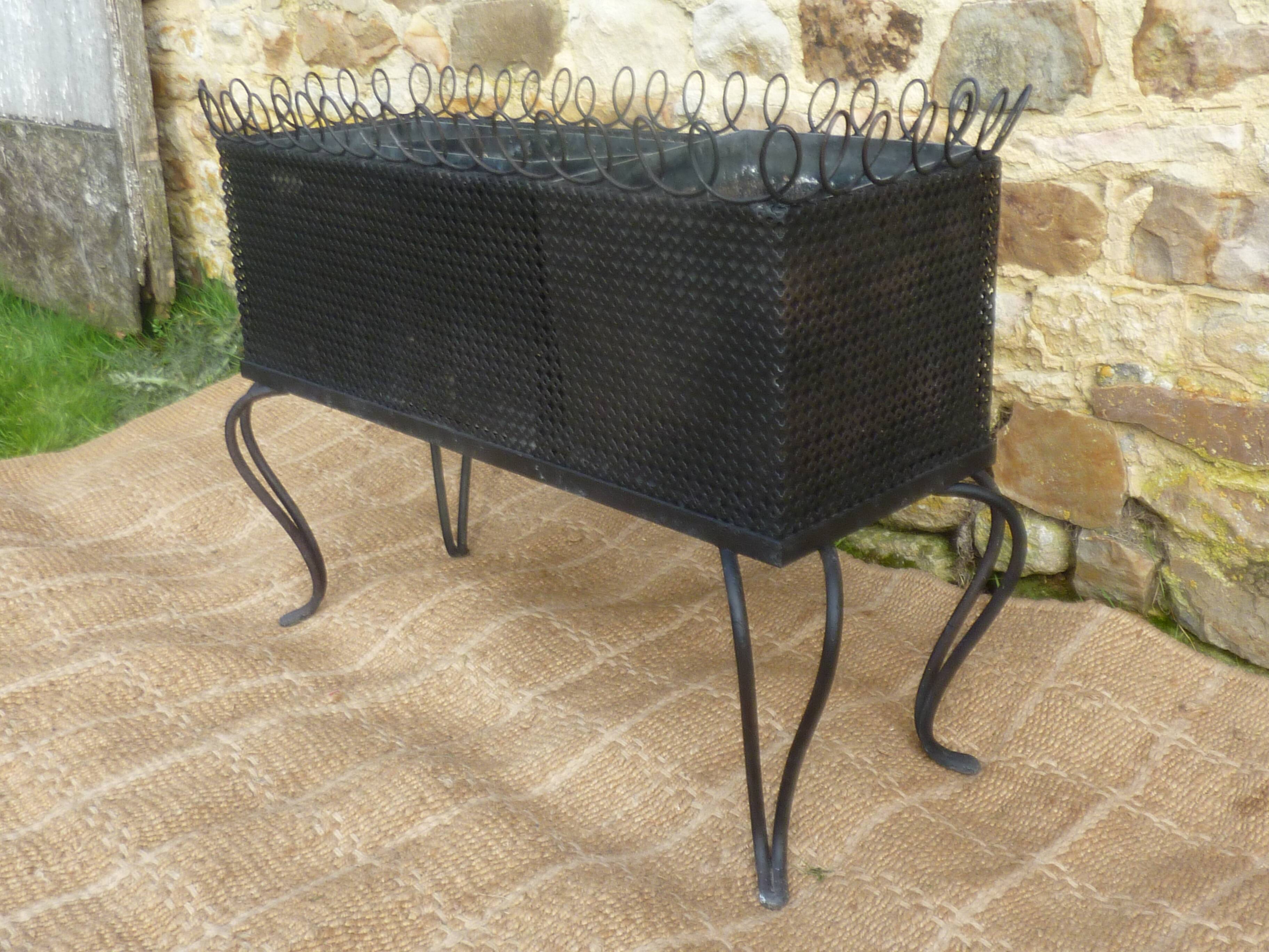 Black perforated metal planter from the 1950s