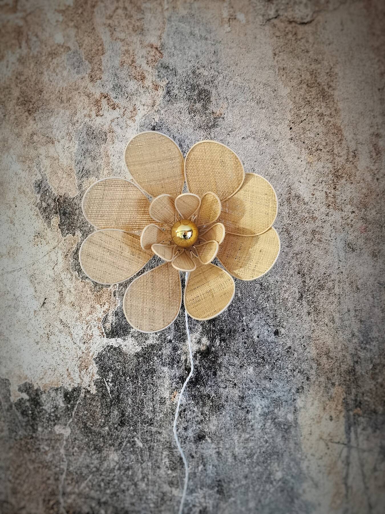 Flower wall light made of rattan and raffia petals