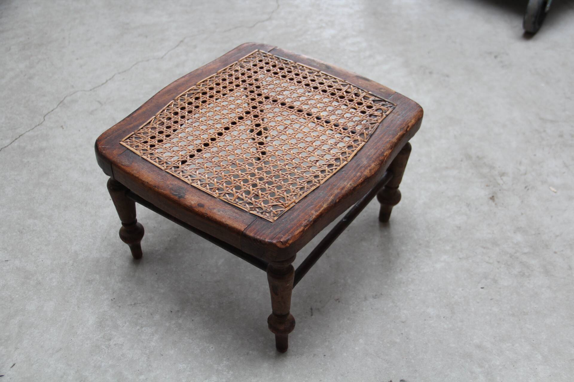 Antique caned wood footrest
