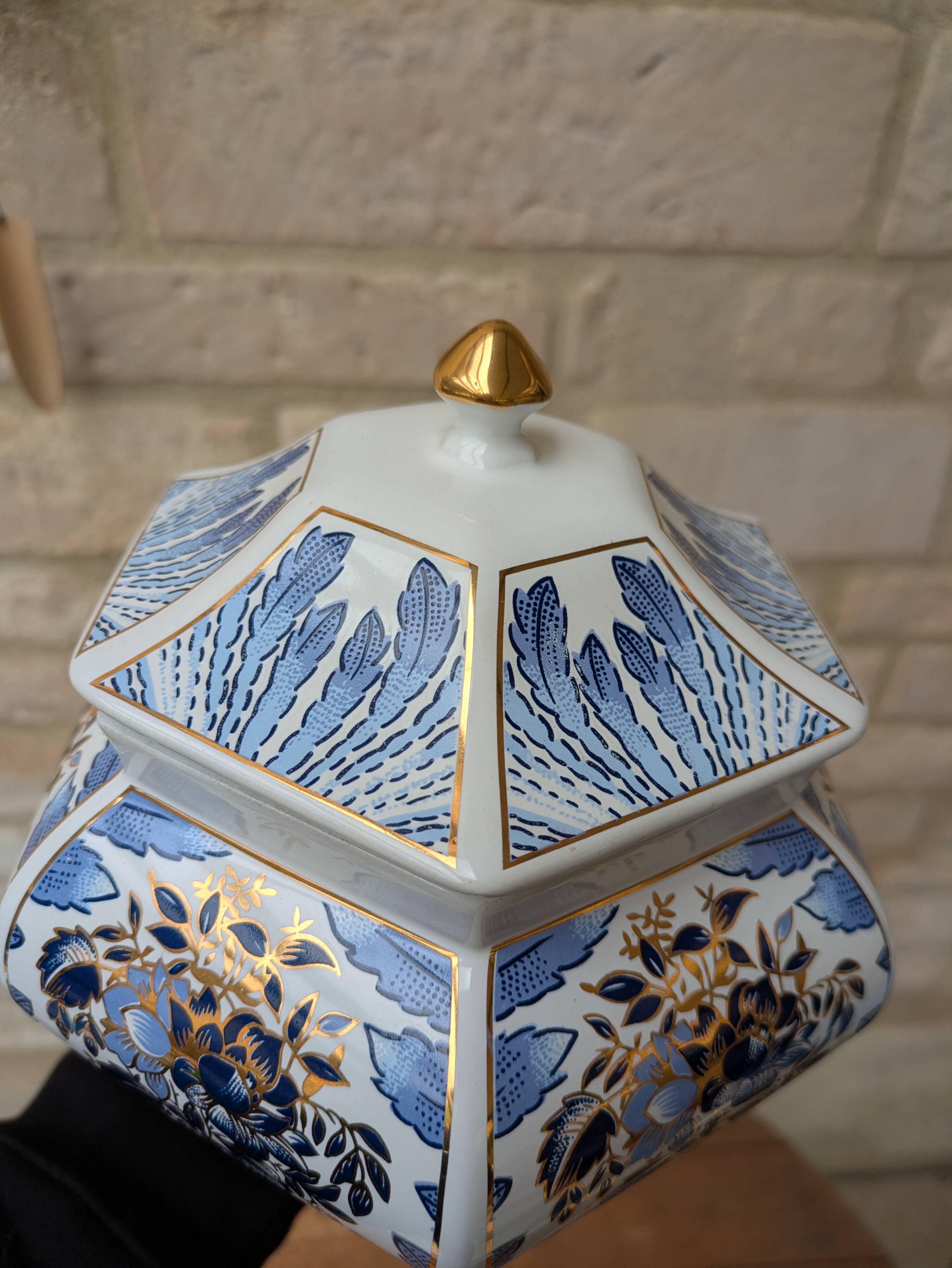 Decorative pot jar with a lid featuring a blue floral pattern and gilding.