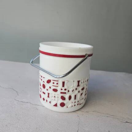 Vintage white opaline ice bucket with red patterns.