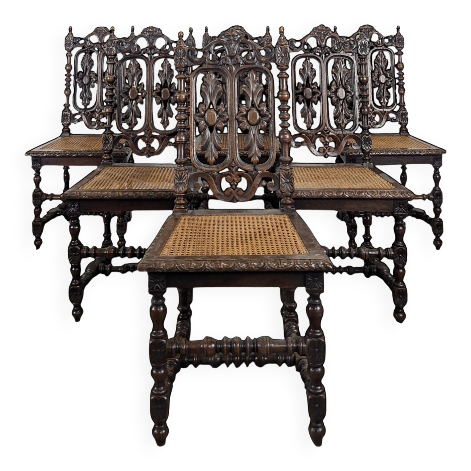 Set of 6 Henri II chairs in carved openwork oak with caned seats.