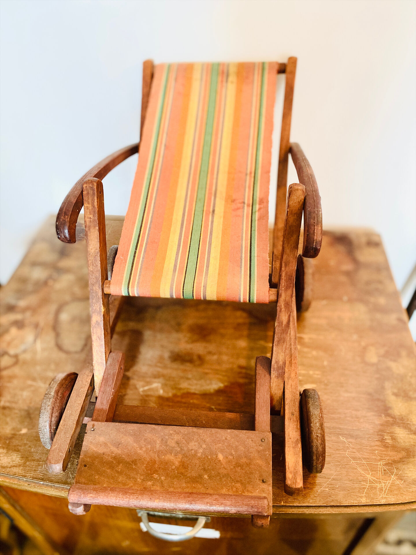 Vintage wooden folding doll's deckchair on wheels