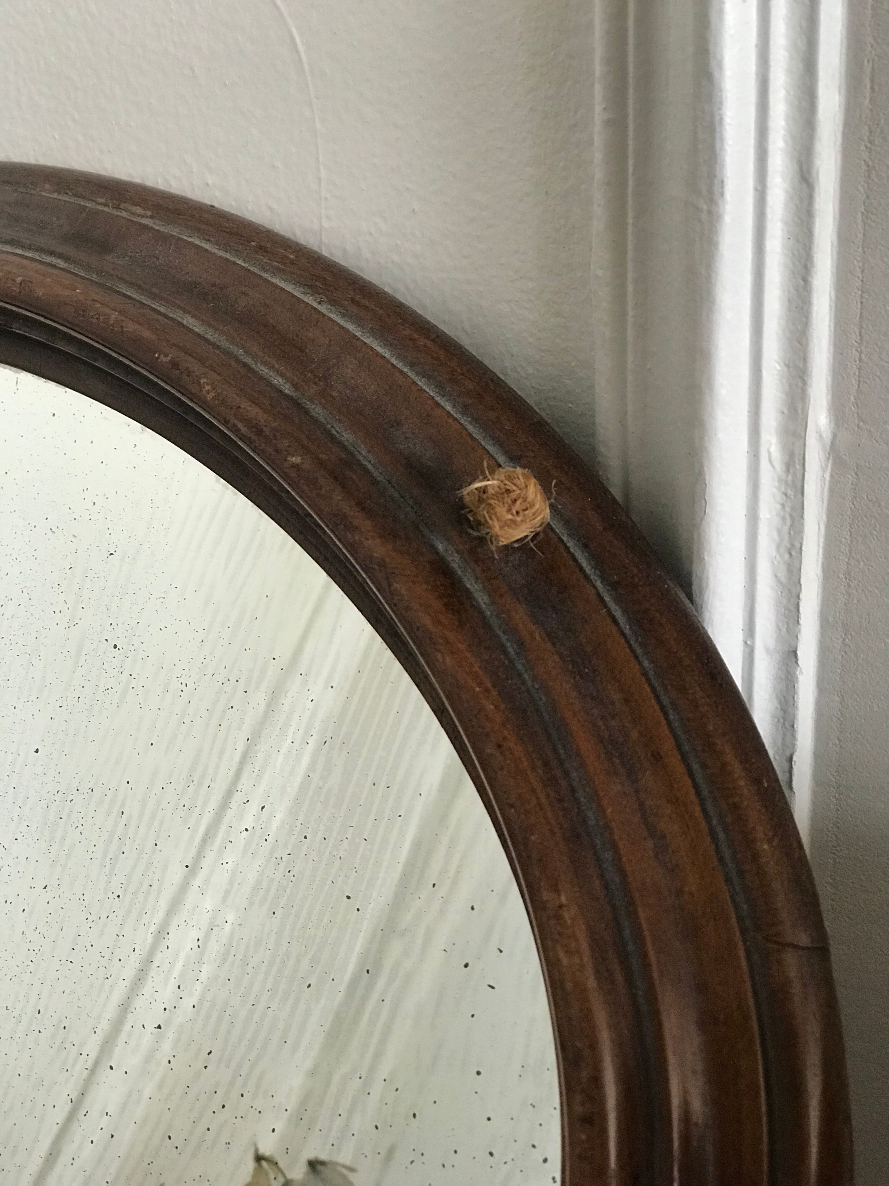 Old oval mirror with wooden frame