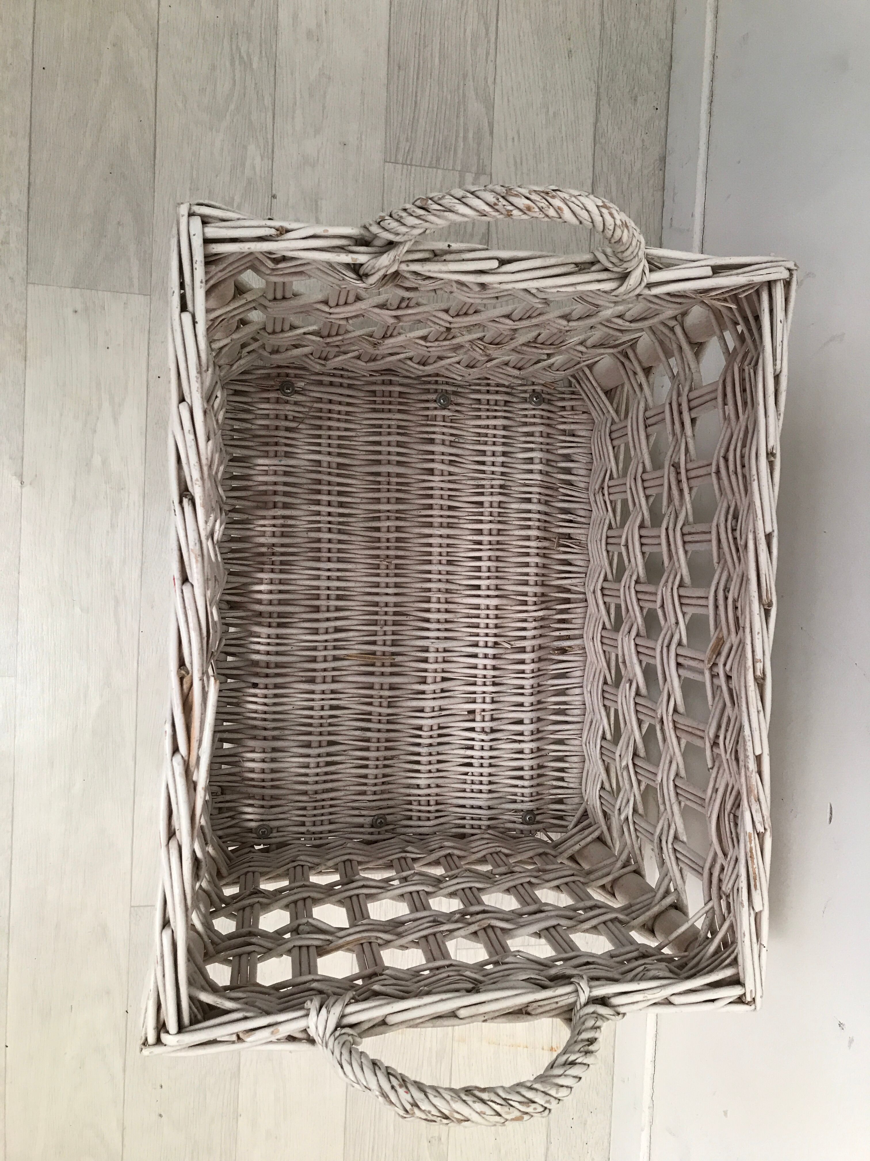 Wicker laundry basket on vintage wooden wheels