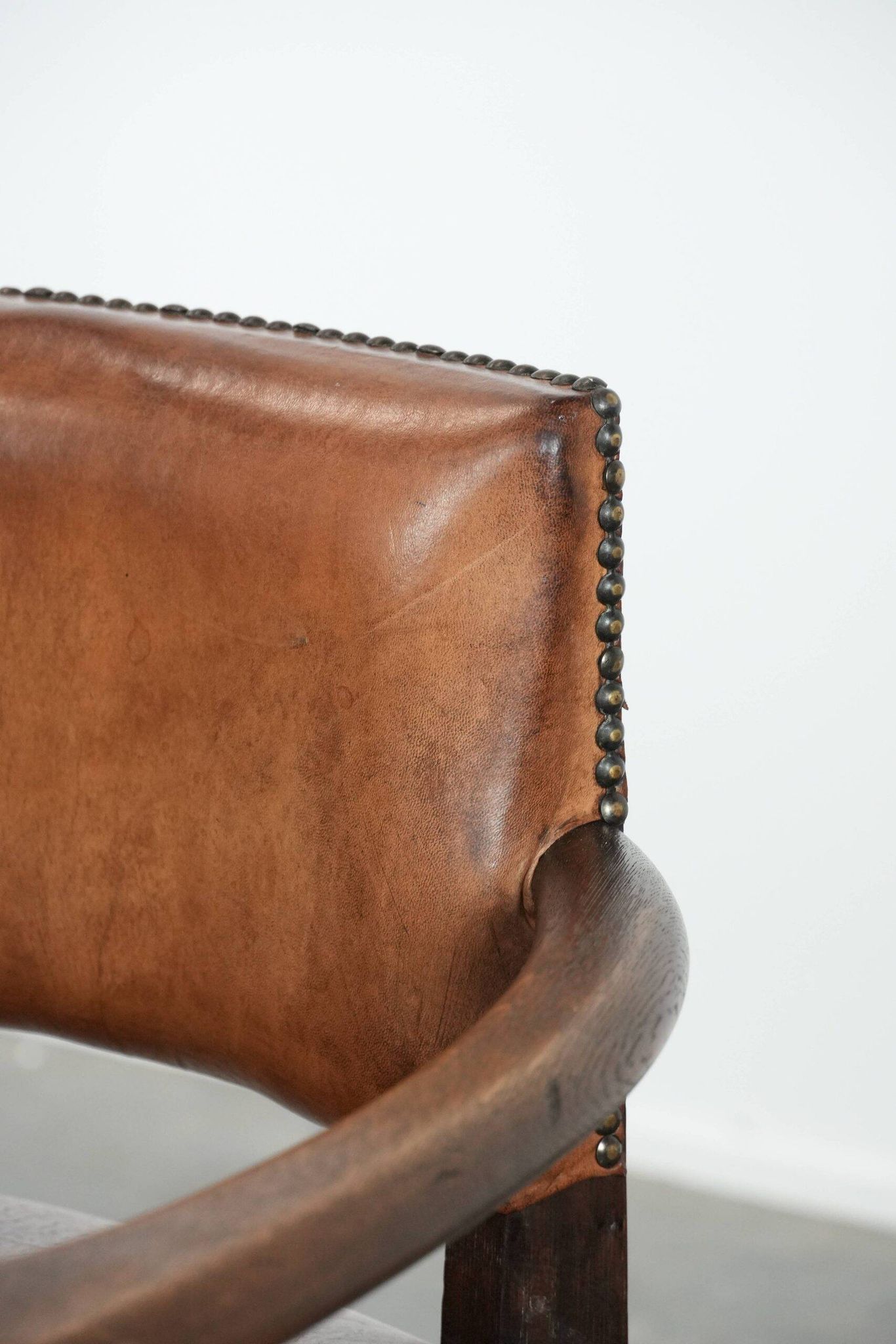 Elegant antique sheepskin leather desk chair with a heavy wooden frame