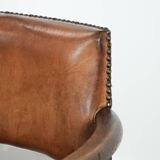 Elegant antique sheepskin leather desk chair with a heavy wooden frame