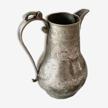 Old oriental pitcher in chiseled silver-plated copper