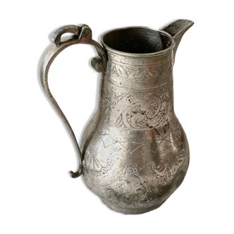 Old oriental pitcher in chiseled silver-plated copper