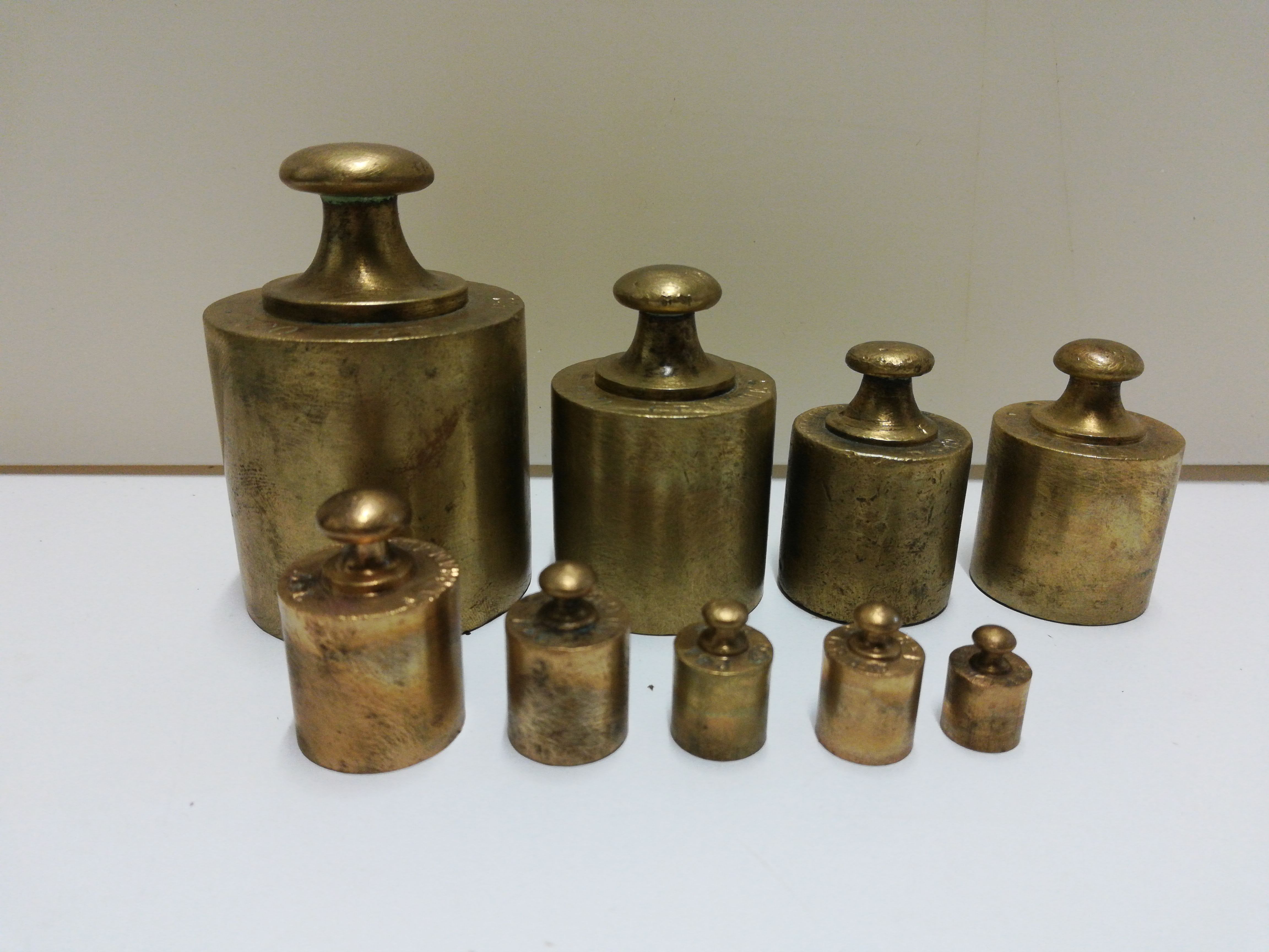 Brass weight series on wooden support