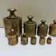 Brass weight series on wooden support