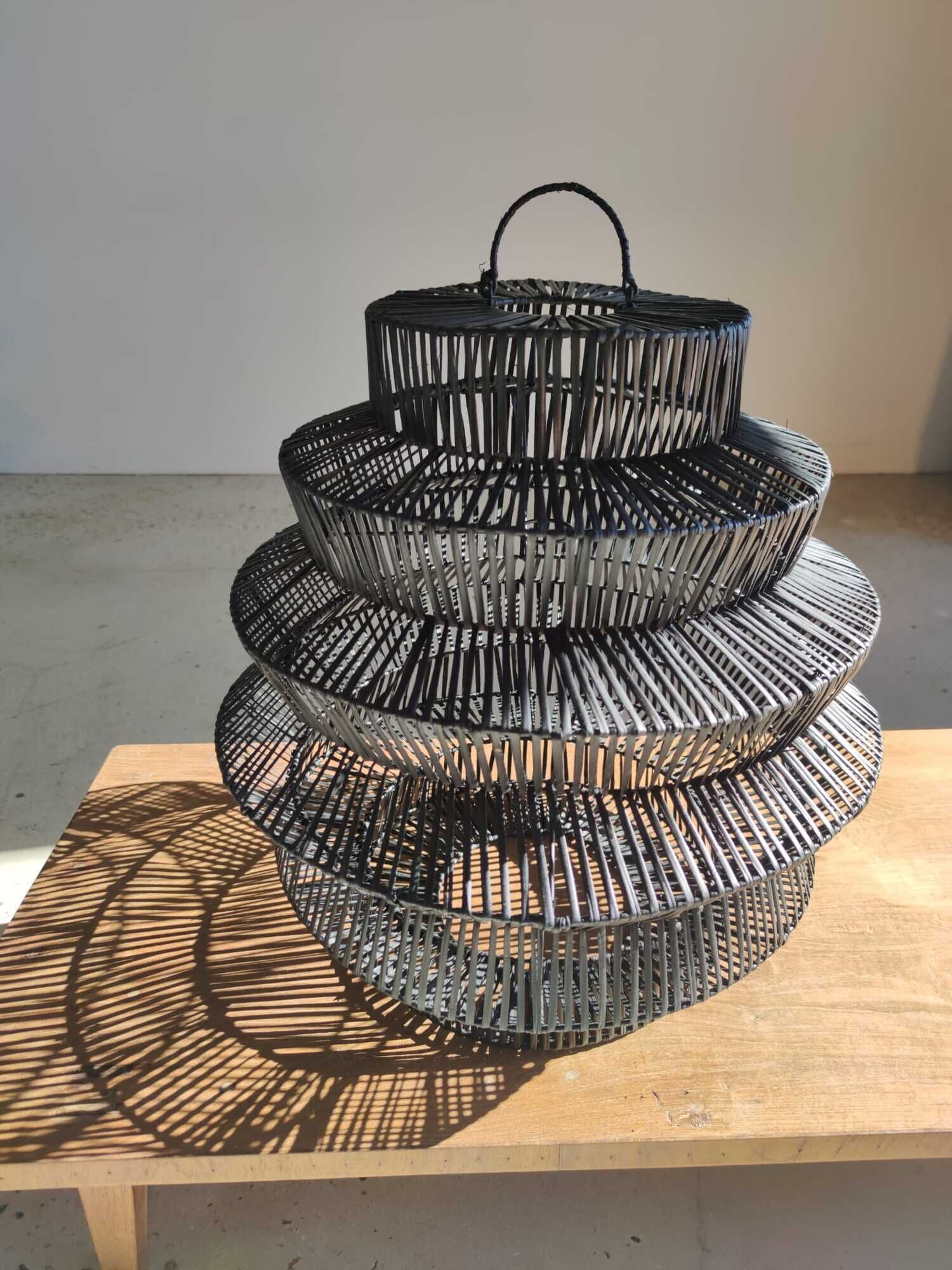Braided rattan suspension in the shape of a black accordion