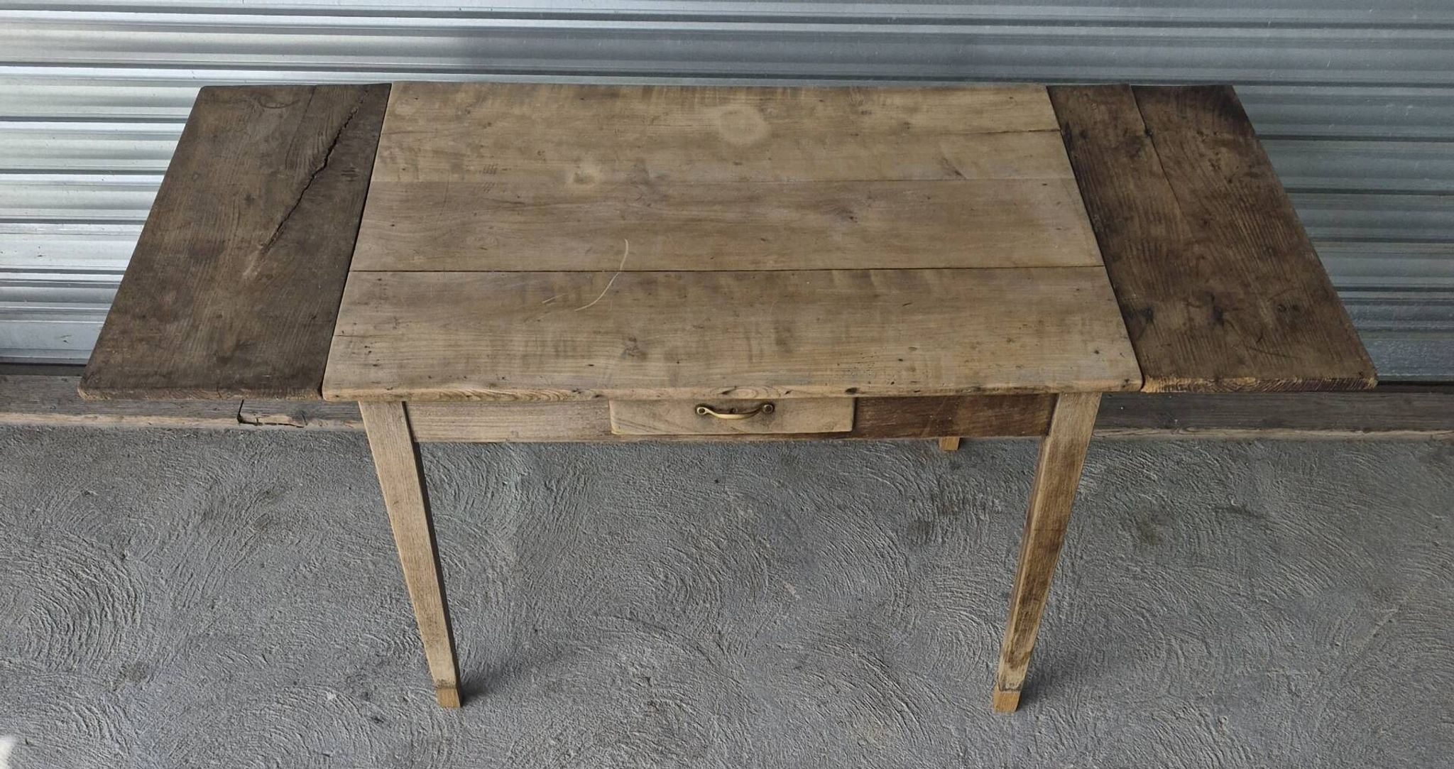 Old farmhouse table with its 2 extensions and raised legs.
