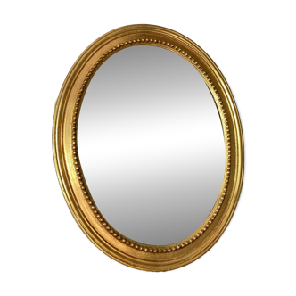 Oval-shaped wooden mirror in gold color
