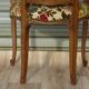 Convertible armchair with brocade fabric and floral patterns.