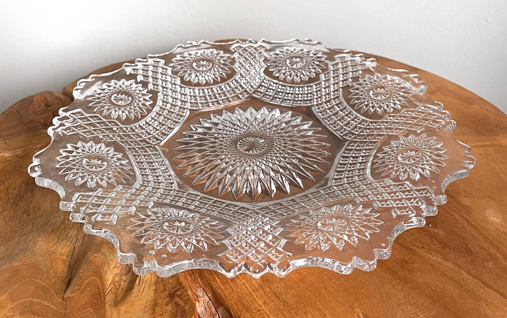 Vintage pressed glass plate with rosette design, octagonal rim, star pattern reminiscent of mandala