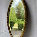 Vintage carved and gilded oval wall mirror