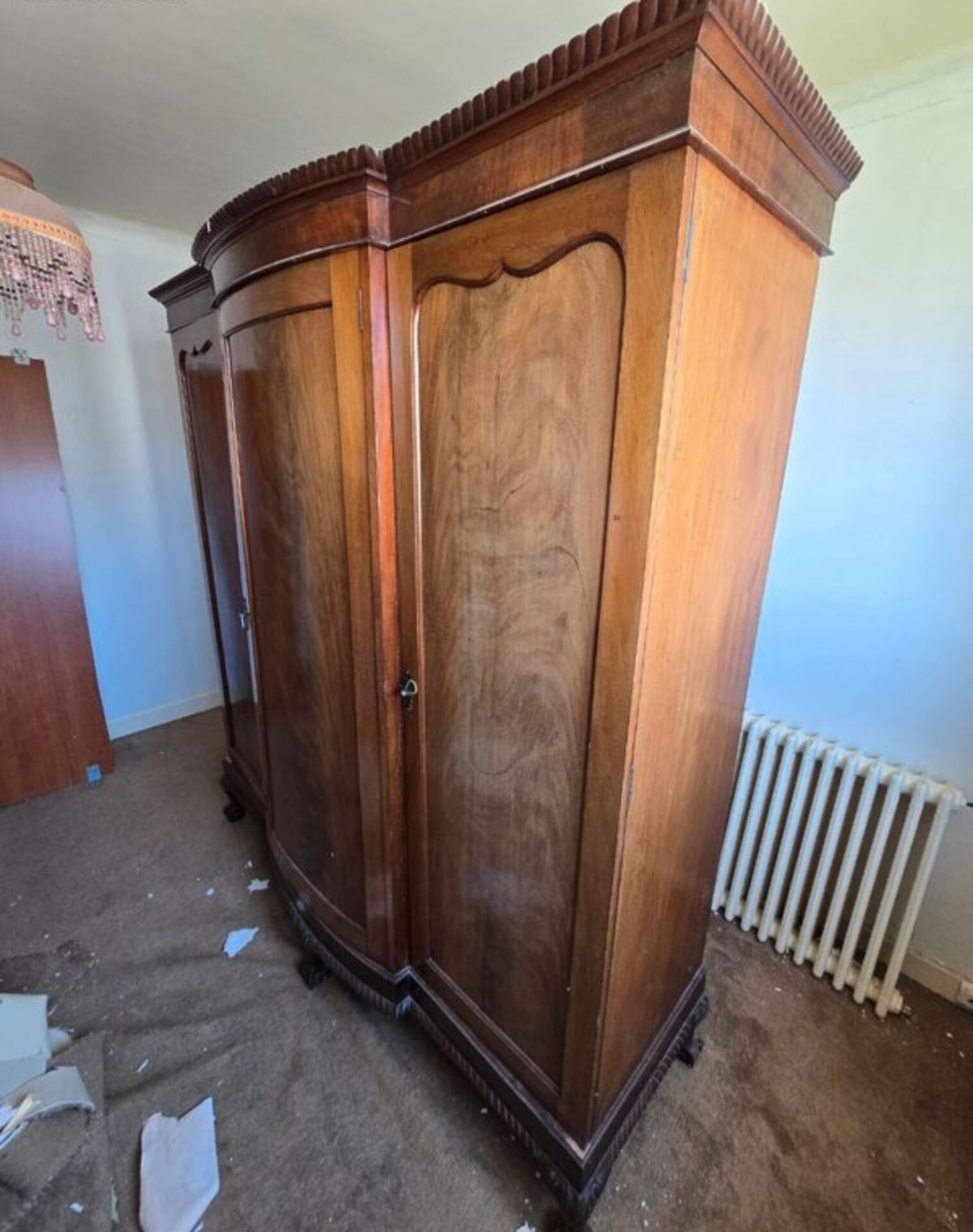 Large English-style wardrobe with a curved front and three doors.
