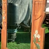 Pretty beveled mirror with wooden frame and floral decoration.