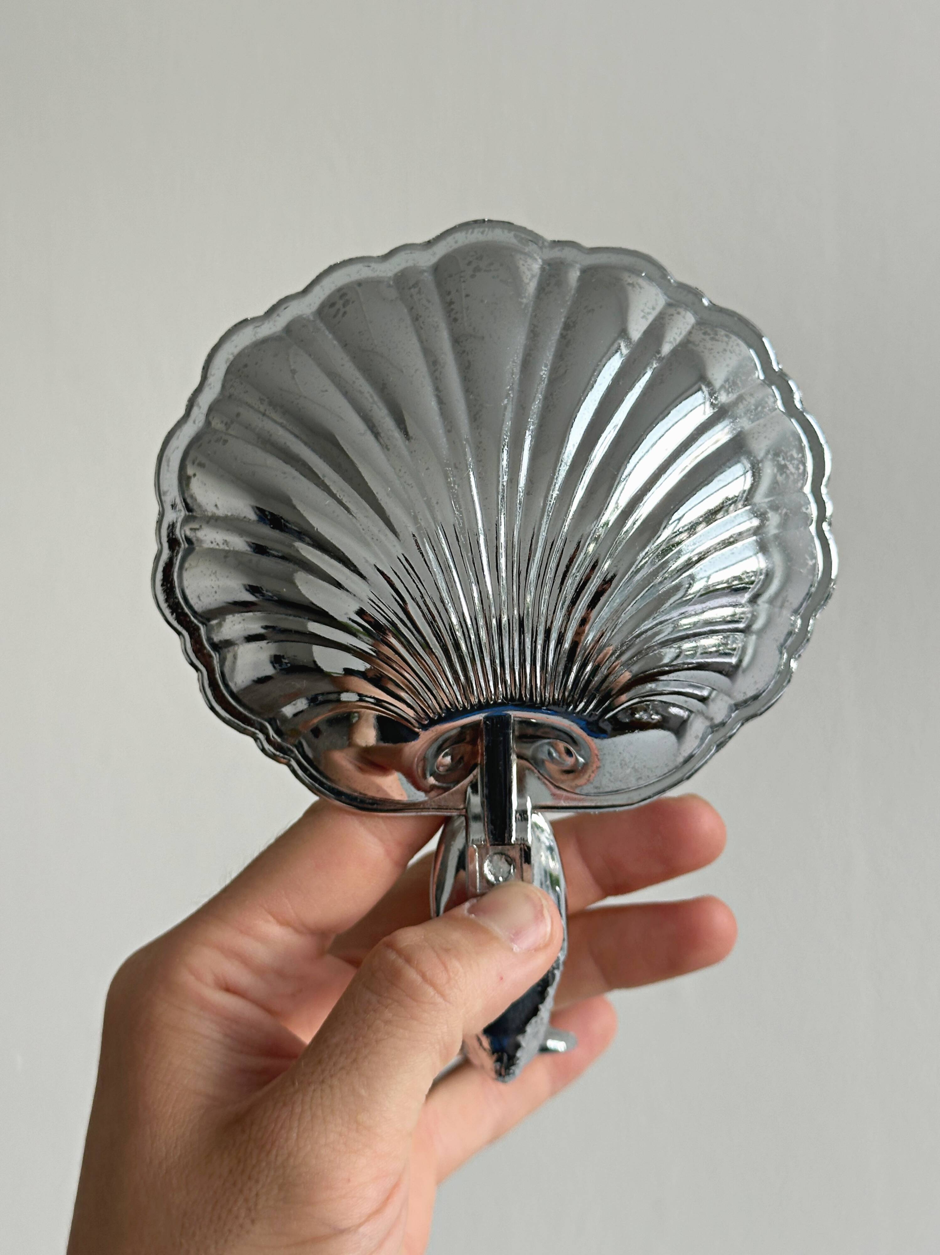 Soap dish, shell-shaped lightweight metal catchall.