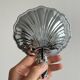 Soap dish, shell-shaped lightweight metal catchall.