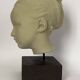Plaster head of a young girl on a pedestal.