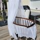 Old wooden rocking chair with turned legs and plumetis fabric.