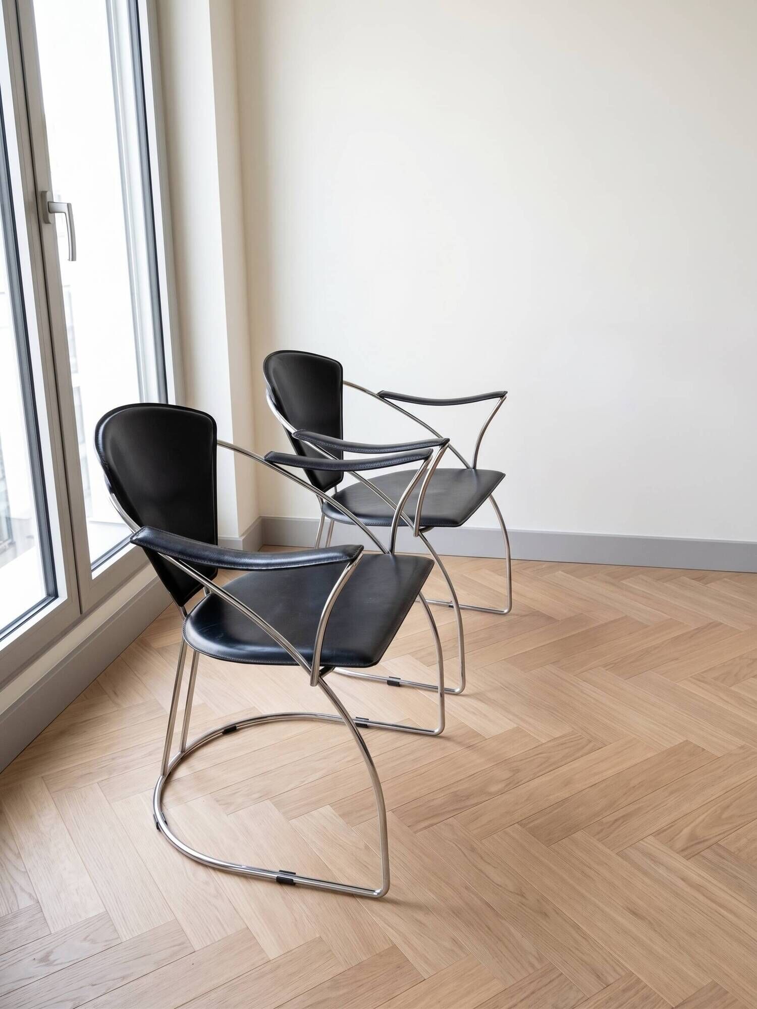 Pair of Linda Arrben armchairs from the 1970s in metal and black leather.