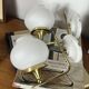 Pair of vintage wall sconces in brass with white glass globe shades.
